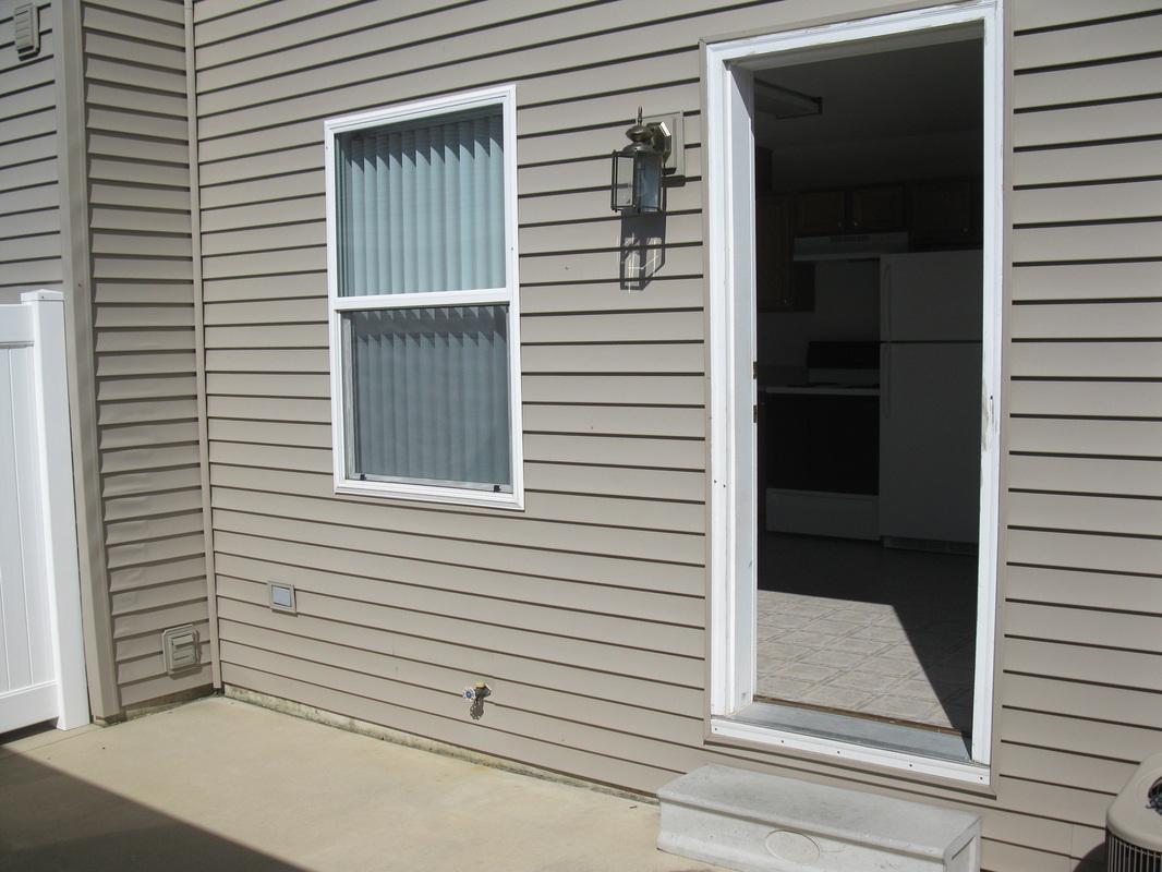 On the patio looking towards door leading to the kitchen in 400 Place Town home