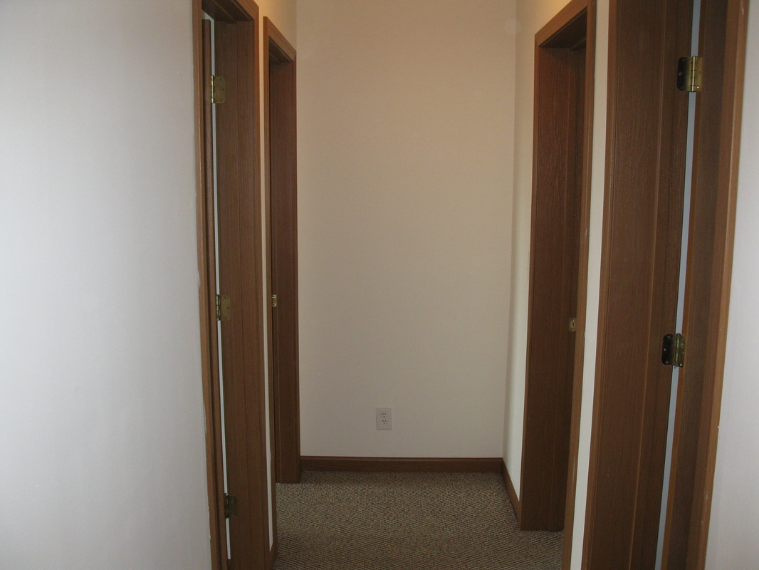 Upstairs hallway view in 500 Place 3 bedroom town home with bathroom on the first left, master bedroom on the second left, and other two bedrooms on the right