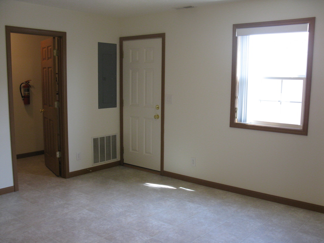 Kitchen view with laundry room to the left and back patio door on the right